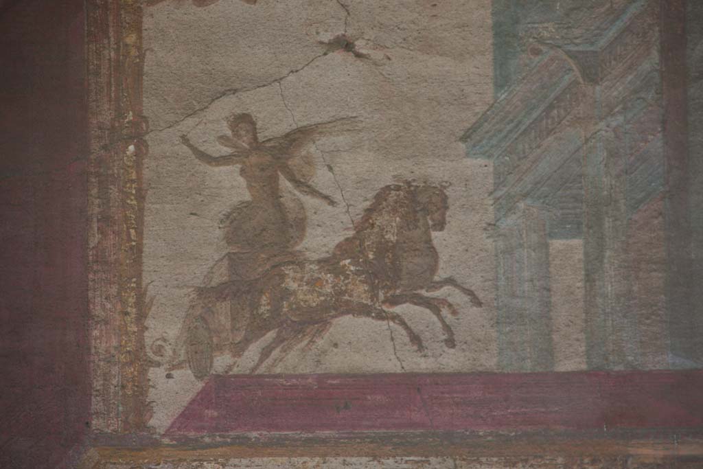 VII.9.7 and VII.9.8 Pompeii. Macellum. April 2013. 
Detail from west wall in north-west corner. Painting of winged figure (Victory?) in chariot. Photo courtesy of Klaus Heese.