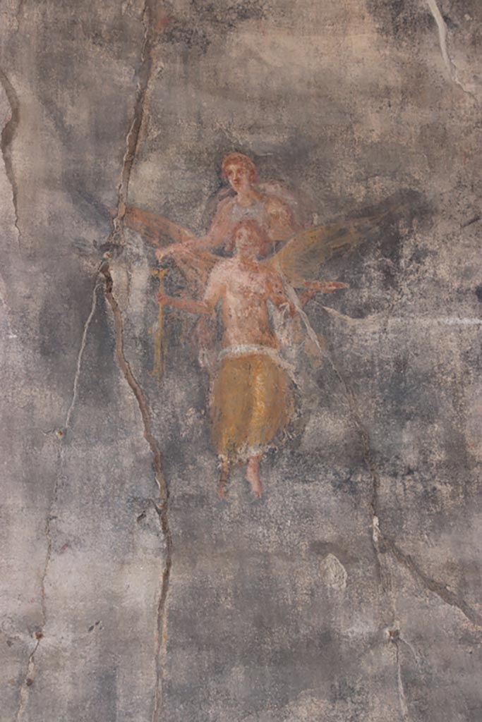 VII.9.7/8 Pompeii. October 2022. 
Flying figures in centre of panel at north end of west wall. Photo courtesy of Klaus Heese.