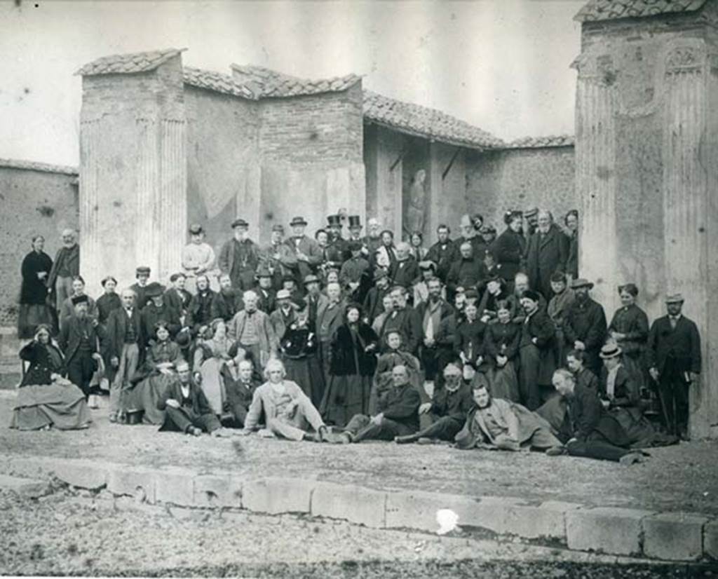 VII.9.7 and VII.9.8 Pompeii. Macellum. Thomas Cook’s party in 1868 in front of the shrine.
Thomas Cook himself sits upright in the centre of the front row, fourth from the right.
Photo courtesy of Rick Bauer. 
Our thanks to Paul Smith, Company Archivist at Thomas Cook UK & Ireland, for his assistance with this.
The original photo is in the Thomas Cook Archives now held in the Record Office for Leicestershire, Leicester and Rutland.