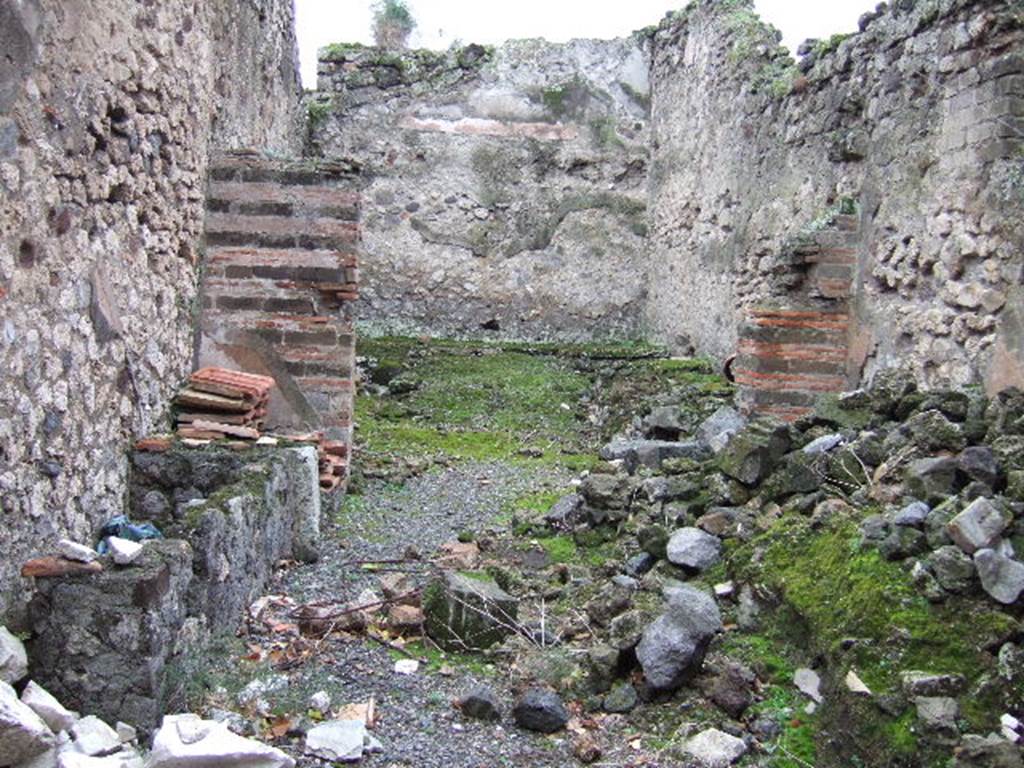 VII.9.44 Pompeii. December 2005. Looking south across workshop. In the front workshop on the left, there would have been a stairs to an upper floor with remains of masonry tanks or wash-basins beneath. In the rear room, there would have been a podium with two furnaces and boilers with chimneys for the smoke, a hearth and nearby a basin. See Notizie degli Scavi, 1899, (p.389)