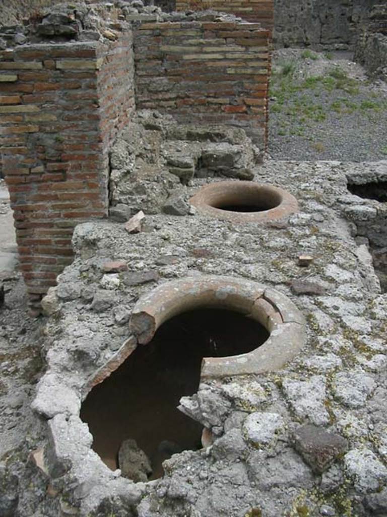 VII.9.54/5 Pompeii. May 2003. Looking east along north counter from rear, with remains of dolia and display shelving. Photo courtesy of Nicolas Monteix.