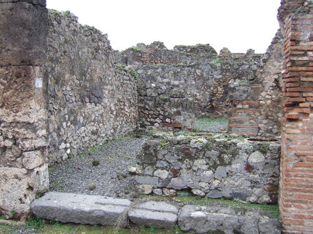 VII.9.56 Pompeii. December 2005. Looking west from entrance across counter to doorway to rear room.