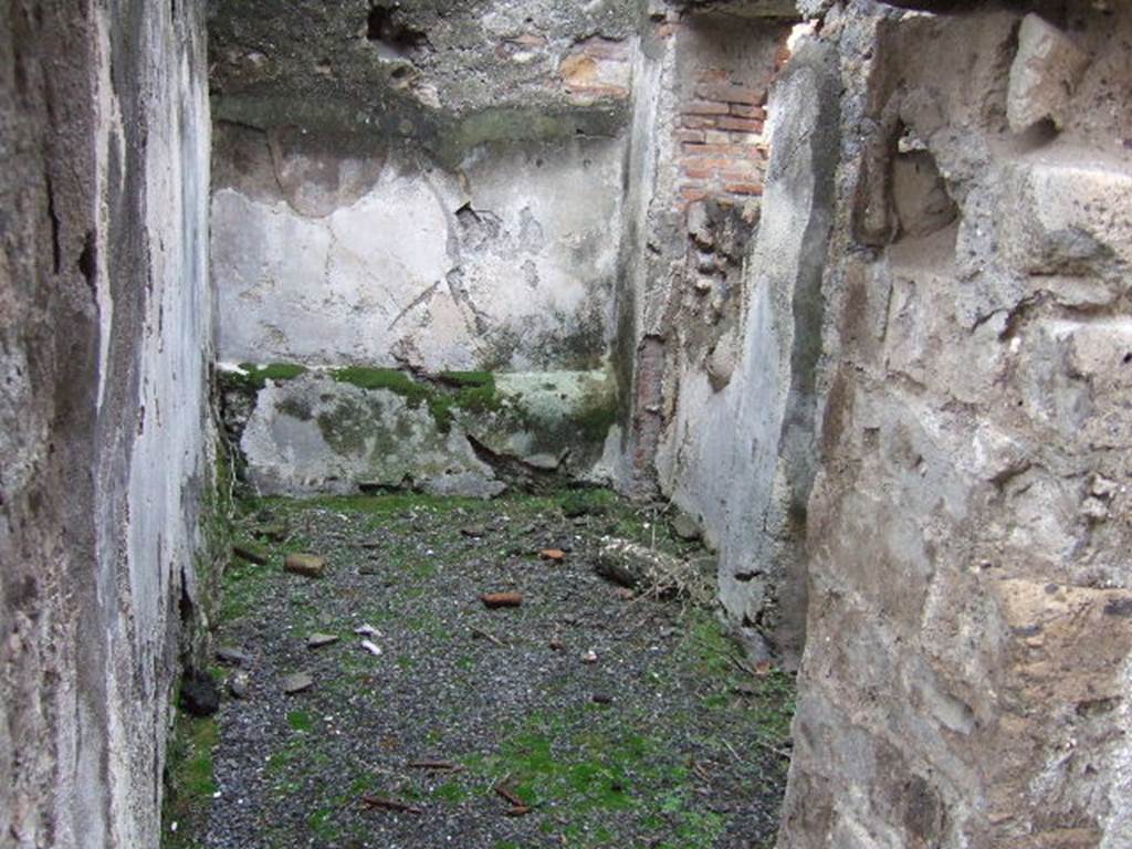 VII.10.3 Pompeii. December 2005. Room 2, the cella ostiaria on south side of entrance, with a doorway (now blocked) which gave direct access to Vicolo di Eumachia. The floor, originally, would have been formed of cocciopesto. (p.54).  The threshold of the doorway was composed of three slabs, grey marble, white marble and travertine. (p.73)
 Studi della Soprintendenza archeologica di Pompei, 22: l”Insula VII, 10 di Pompei , by Angelo Amoroso.