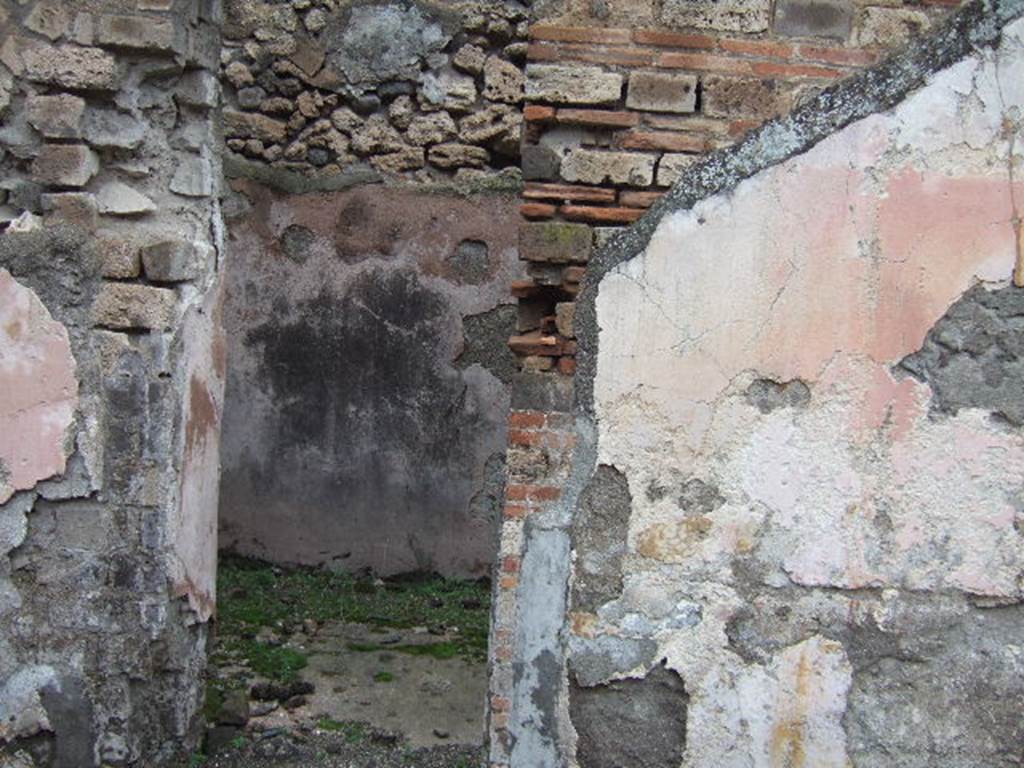 VII.10.3 Pompeii. December 2005. Doorway to room 5, a cubiculum on north side of atrium.
This room had a floor of red cocciopesto. The door threshold formed of two rectangular travertine slabs, was also marked in the centre with a circular recess for the fixing of the double-door hinges.  When redecorated this room was repainted with red plaster walls, of which some traces remain. Its original flooring was kept. 
Studi della Soprintendenza archeologica di Pompei, 22: l”Insula VII, 10 di Pompei, by Angelo Amoroso, (p.54 and p.74)