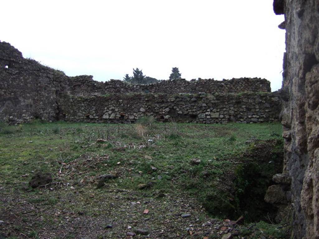 VII.11.1 Pompeii. December 2005. Looking south. According to Jashemski, this area, from which old construction had been cleared after the earthquake, was identified by Fiorelli as a plant nursery. The plant-bed at the right of the entrance (on the right of the photo) was originally outlined by 12 amphorae. These had their tops broken off, had been filled with soil and been sunk into the ground. They were used to start the seedling growing.
See Jashemski, W. F., 1993. The Gardens of Pompeii, Volume II: Appendices. New York: Caratzas. (p.192)