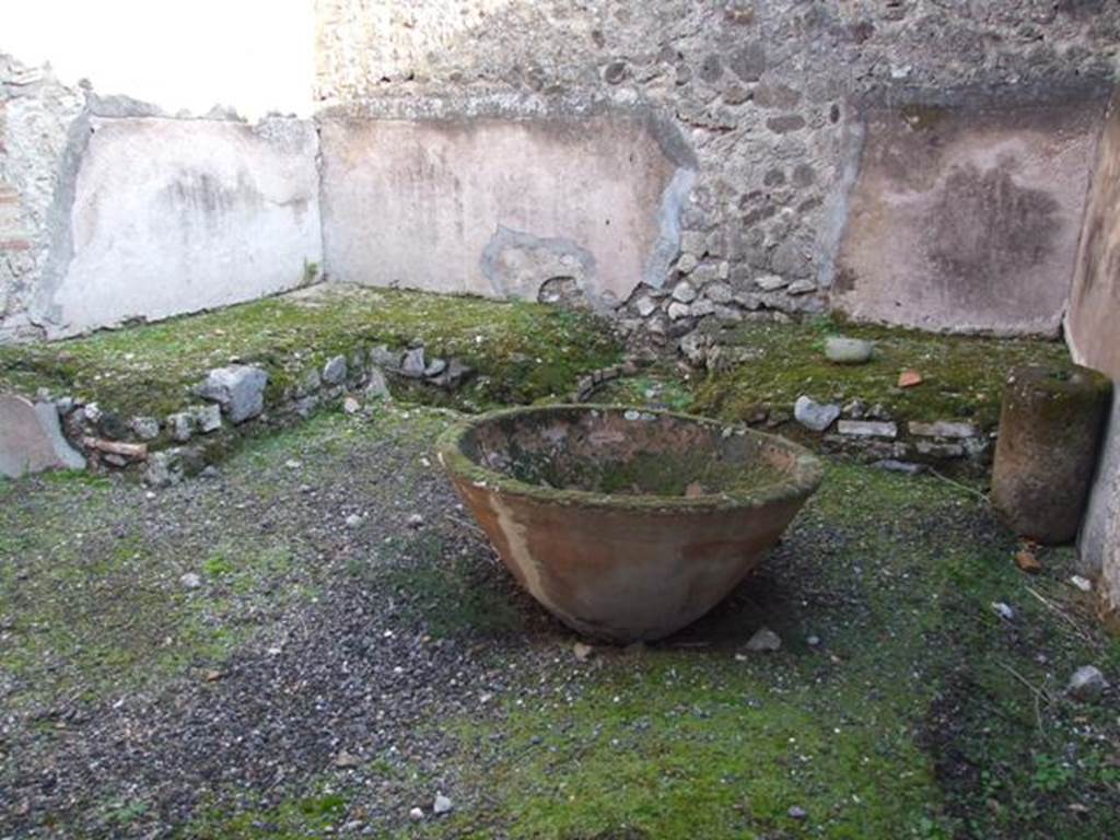 VII.11.5 Pompeii. December 2007.  Podium with remains of hearth and large terracotta pot for washing the cloth.