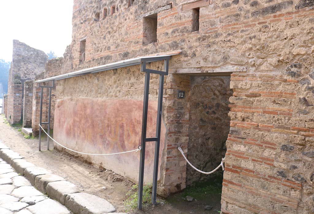 VII.11.12, Pompeii. December 2018. 
Looking south to entrance doorway on west side of Vicolo del Lupanare. Photo courtesy of Aude Durand.