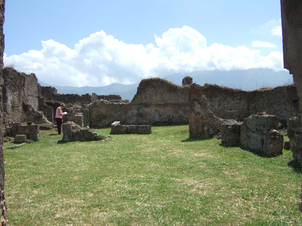 VII.12.3 Pompeii. May 2006. Looking south towards peristyle garden.
According to Jashemski, at the rear of the large atrium was a peristyle garden, excavated in 1863.
This was enclosed by a portico on the north and east supported by two columns.
It was bordered by a low wall which had an entrance to the garden on the north.  
At the west end of the garden was a shallow marble pool which had a fountain.  
The triclinium off the north portico had a wide opening which gave a good view of the garden and fountain, as did the exedra on the east.
See Jashemski, W. F., 1993. The Gardens of Pompeii, Volume II: Appendices. New York: Caratzas. (p.193)