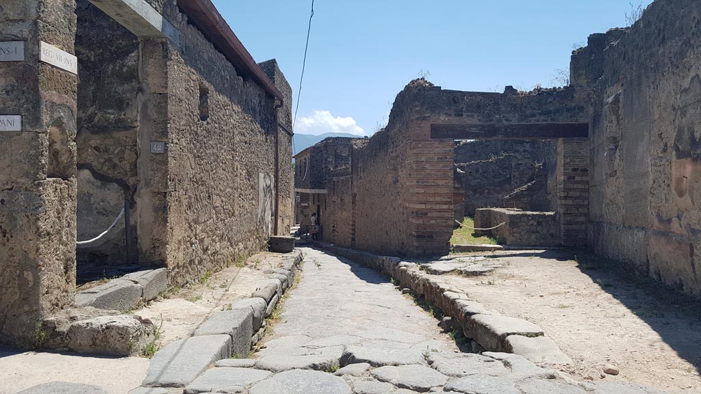 VII.12.15 Pompeii, on right. August 2023. 
Looking south along Vicolo del Lupanare, with VII.1.42, on left. Photo courtesy of Maribel Velasco.