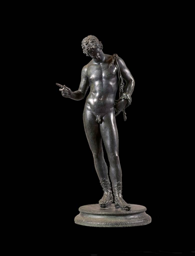 VII.12.17.21 Pompeii. June 1862. Bronze statue found in the small room near the entrance at VII.12.17.
Fiorelli identified it on excavation as possibly a statue of Narcissus.
See Pappalardo, U., 2001. La Descrizione di Pompei per Giuseppe Fiorelli (1875). Napoli: Massa Editore. (p.112).
Mau identified it as a statue of Dionysus, and it is now displayed as this.
See Mau, A., 1907, translated by Kelsey F. W. Pompeii: Its Life and Art. New York: Macmillan. (p.452).
Now in Naples Archaeological Museum. Inventory number 5003.
According to Kuivalainen –
The condition of the statuette is good but the original base has been replaced and the panther is lost.
Kuivalainen comments –
The male’s apparel and the position of the right-hand fingers identifies the bronze as Bacchus dangling a bunch of grapes above a panther.
The iconographic formula is also known from wall paintings in Pompeii.
See Kuivalainen, I., 2021. The Portrayal of Pompeian Bacchus. Commentationes Humanarum Litterarum 140. Helsinki: Finnish Society of Sciences and Letters, (H14, p.219).