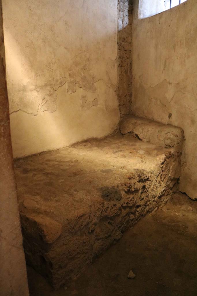 VII.12.18 Pompeii. December 2018. 
Looking towards stone bed and pillow in room for prostitute. Photo courtesy of Aude Durand.