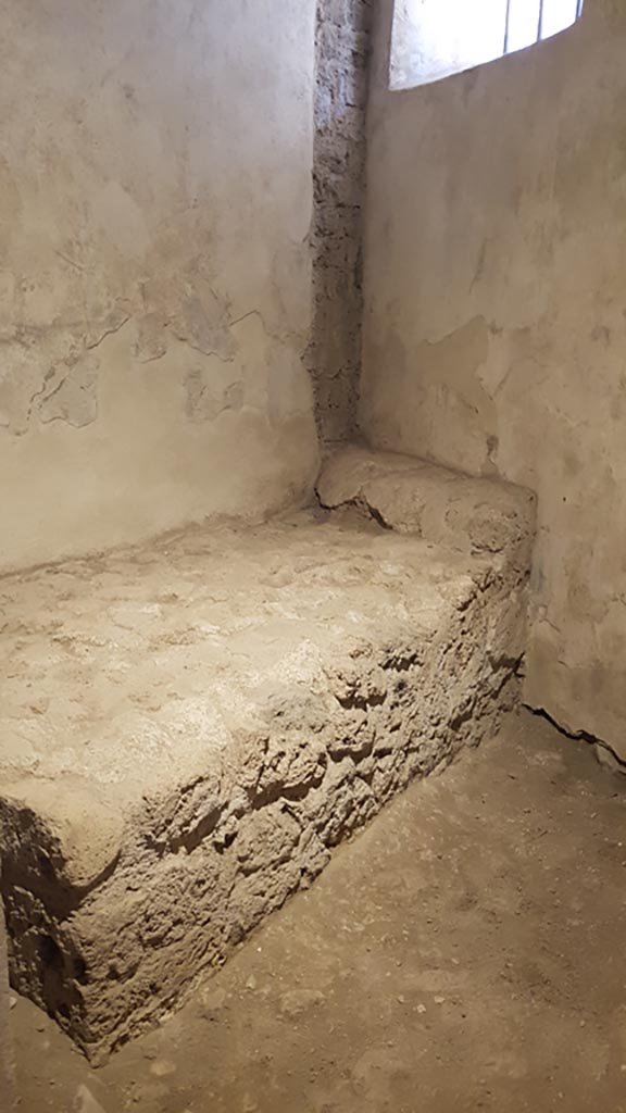 VII.12.8 Pompeii. August 2023. 
Stone bed and pillow in room for prostitute. Photo courtesy of Maribel Velasco.