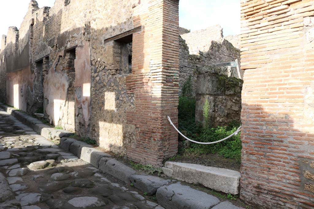 VII.12.21 Pompeii on right. December 2018. 
Looking towards entrance doorway on north side of Vicolo del Balcone Pensile. Photo courtesy of Aude Durand.