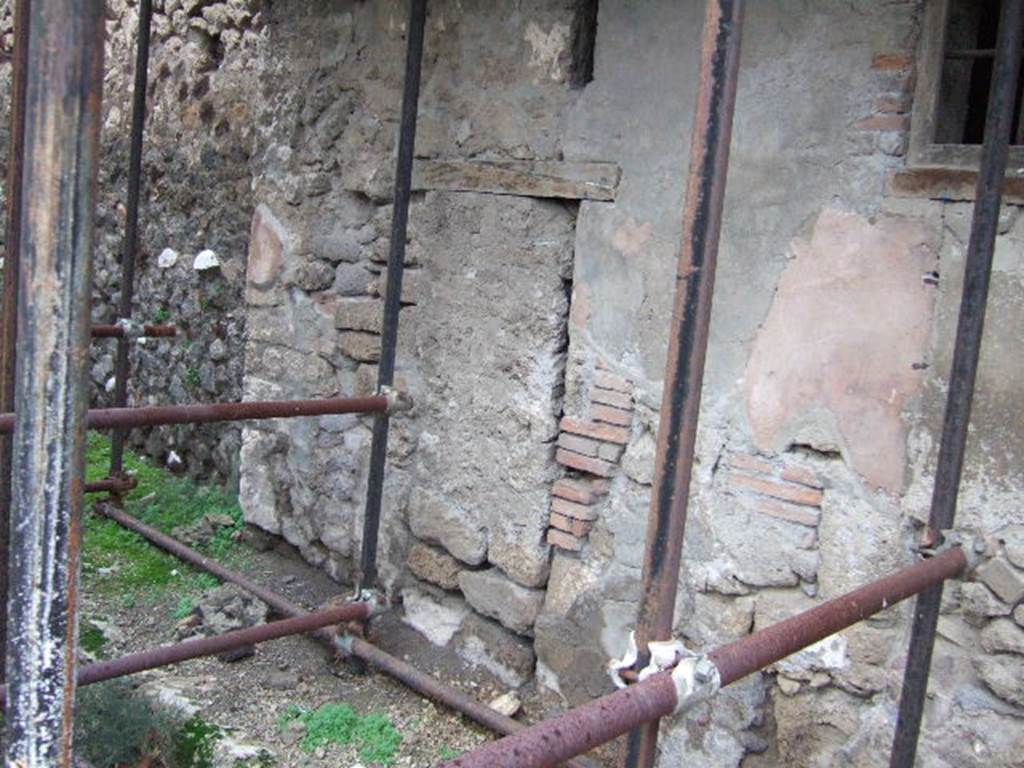 VII.12.29 Pompeii. December 2005. Blocked entrance. According to Eschebach, this doorway led to a public latrine. See Eschebach, L., 1993. Gebäudeverzeichnis und Stadtplan der antiken Stadt Pompeji. Köln: Böhlau. (p.331) According to Hobson, the latrine is not evident.
See Hobson, B. 2009. Pompeii, Latrines and Down Pipes. Oxford, Hadrian Books, (p.392) According to Fiorelli, “a dark and narrow cell, with entrance from the previous house seems to have served as a prison….”  See Pappalardo, U., 2001. La Descrizione di Pompei per Giuseppe Fiorelli (1875). Napoli: Massa Editore. (p.114)