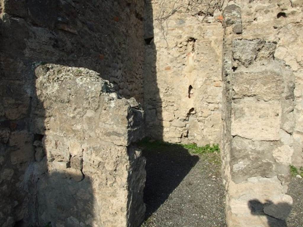 VII.14.2 Pompeii. December 2007. Looking north through doorway to rear room with site of steps to upper floor, and a latrine. According to Boyce, a fragmentary painting on the wall of the kitchen appeared to have belonged to a lararium originally painted above it.  Three men (the heads are missing) are busied about a hog. Below lay the carcass of a slaughtered animal, opened as if for divination from the entrails. He gave the reference – Helbig 83.
See Boyce G. K., 1937. Corpus of the Lararia of Pompeii. Rome: MAAR 14. (p.71, no.325)