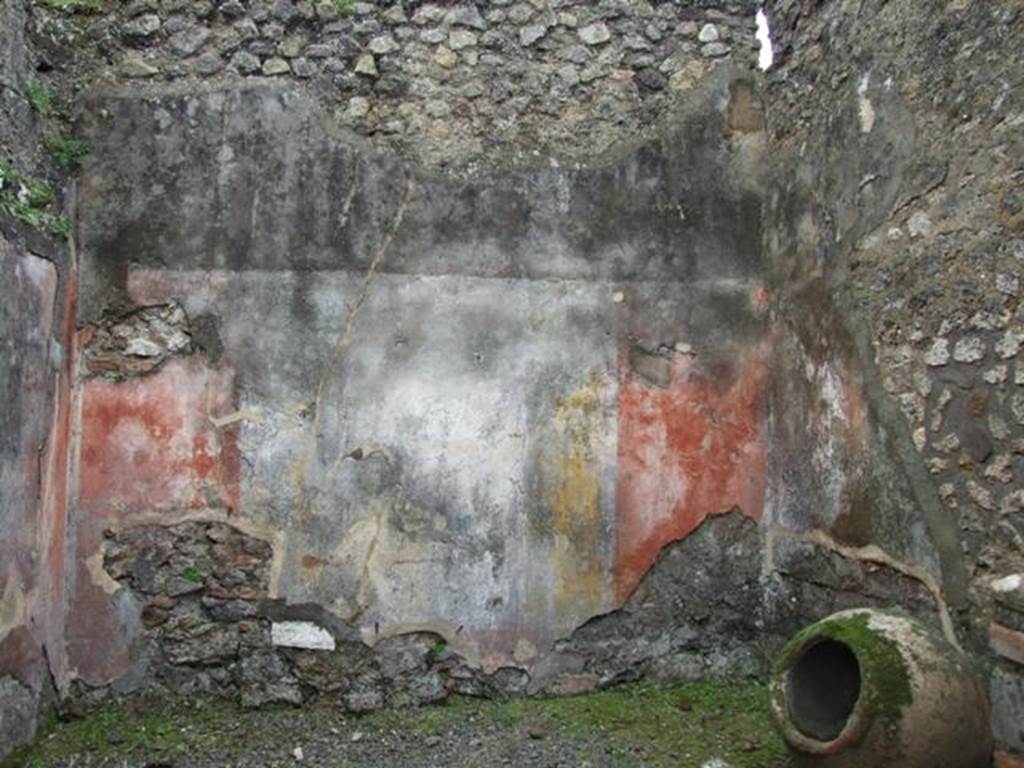 VII.14.5 Pompeii. March 2009. Room 13, south wall with remaining painted plaster. 
The wall would have been painted in the IV Style, with red panels framed by “carpet” borders and two parallel lines.
The borders would have been separated by architectural decoration which showed, according to Fiorelli, three paintings with fish and landscape. 
No trace of these paintings survives on the south wall.