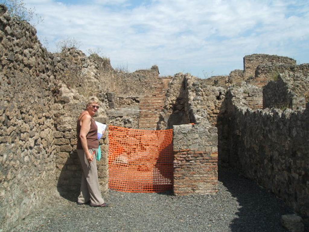 VII.14.13 Pompeii. May 2005. North wall with doorway to rear room, and on the right, steps to upper floor.