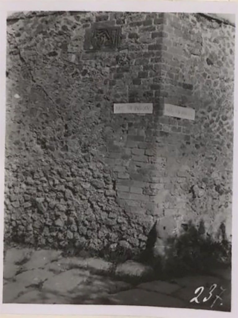 VII.15.1/2 Pompeii. Pre-1943 photo by Tatiana Warscher.
Looking towards plaque high up on west wall of Via dei Soprastanti/Vicolo del Gigante on north-west corner at junction with Vicolo del Gallo. 
See Warscher, T. Codex Topographicus Pompeianus, IX.1. (1943), Swedish Institute, Rome. (no.19b).