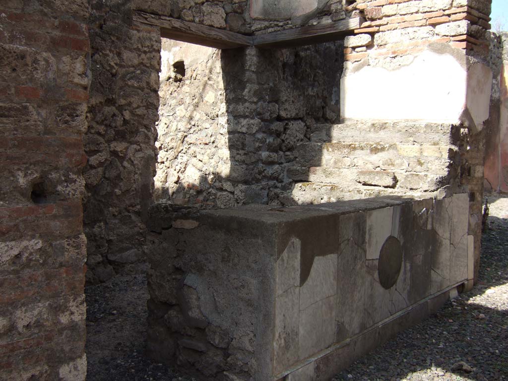 VII.15.5 Pompeii. September 2005. Looking north-west from entrance doorway towards two-sided counter.
Through the doorway, on the left, is the kitchen which can be seen in VII.15.4.