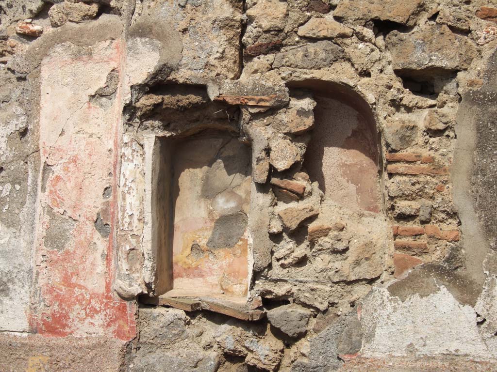 VII.15.5 Pompeii. September 2005. Niches. Boyce recorded a rectangular niche with a red panel on each side.
Each panel was painted with a yellow and black serpent coiling upwards with the head at the top.
See Boyce G. K., 1937. Corpus of the Lararia of Pompeii. Rome: MAAR 14.  (p. 72, no.330, plate 12,3).