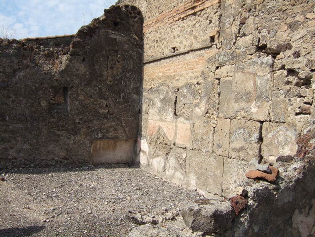 VII.15.9 Pompeii. September 2005. Looking towards the north-west corner of the triclinium, the largest room of the house with white painted stucco above a yellow zoccolo on the walls. A window in the west wall opened towards the courtyard at the rear of house VII.15.13.