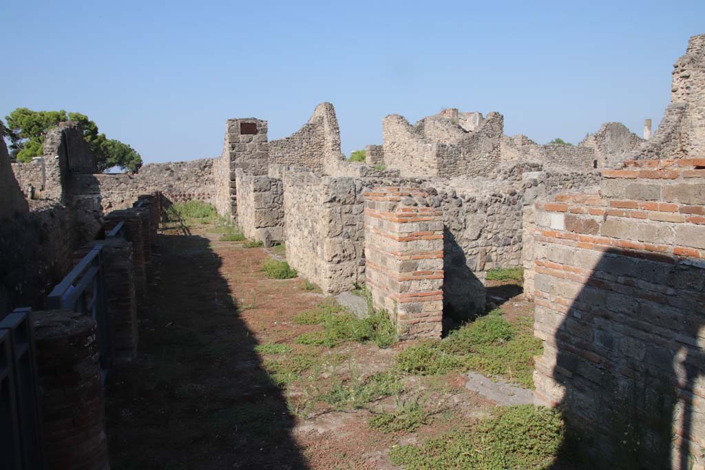 VII.16.1-4 Pompeii. September 2021.  
Looking west along portico with entrance doorway VII.16.1, left of centre, and VII.16.4, on right. Photo courtesy of Klaus Heese.