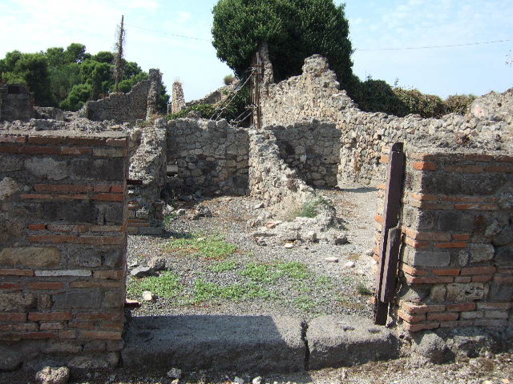 VII.16.9 Pompeii. September 2005. Looking west through entrance doorway.
According to Fiorelli –
“In questo trovasi innanzi tutto un forno, separato da altre localita cui prima stava congiunto, e con due  celle adiacenti, una delle quali servita certamente di apotheca.”
See Pappalardo, U., 2001. La Descrizione di Pompei per Giuseppe Fiorelli (1875). Napoli: Massa Editore. (p.161)
(translation: An oven was found in this, separated from other places with which it had been first joined, and with two adjacent rooms, one of which would have certainly been used as a storeroom/cupboard.”)