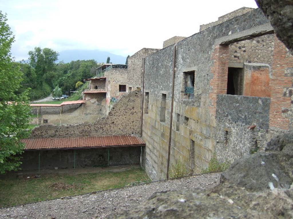 View through hole in wall of VII.16 on Vicolo dei Soprastanti. May 2006. Looking north to rear of complex of M Fabius Rufus, Pompeii. 
The part containing the House of Maius Castricius is on the right.
The large square window, on the right, is from the courtyard garden (see VII.16.22).