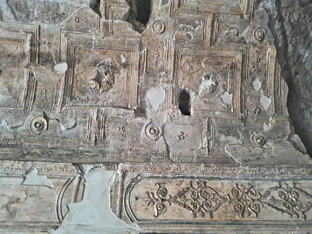 VII.16.a Pompeii. November 2023. 
Room 6, detail of decorative stucco above doorway to room 7 on south wall, in south-west corner. Photo courtesy of Giuseppe Ciaramella.