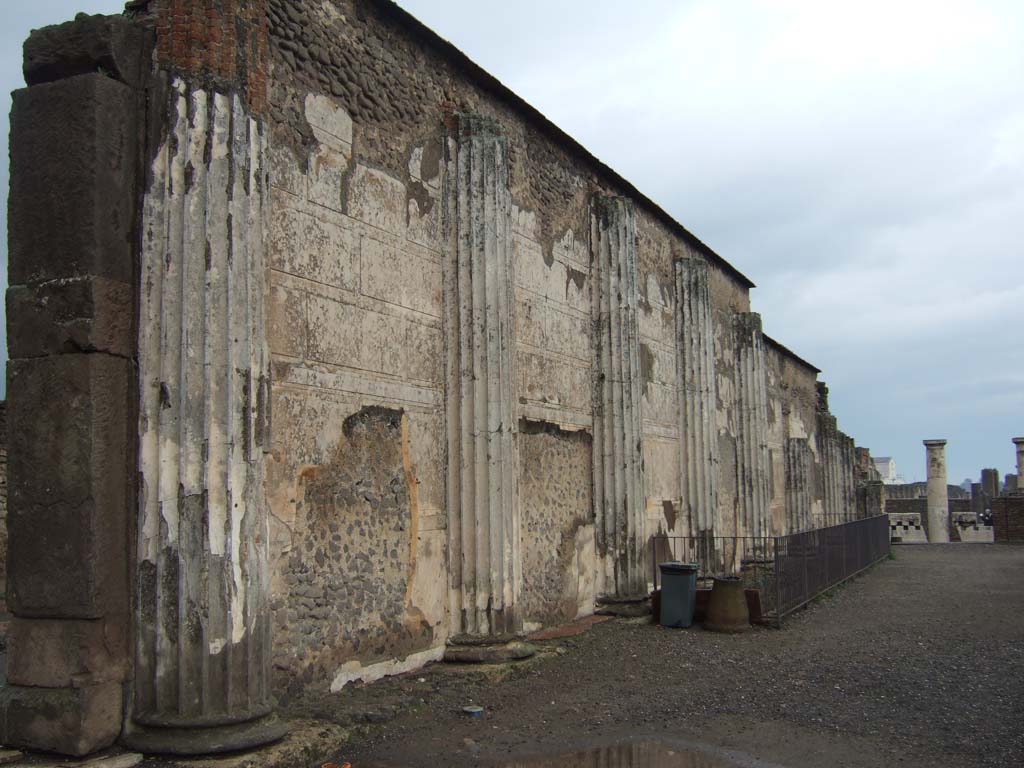 VIII.1.1 Pompeii. December 2005. 
Basilica, north wall and corridor. Looking east along remains of half round columns and stucco plaster.