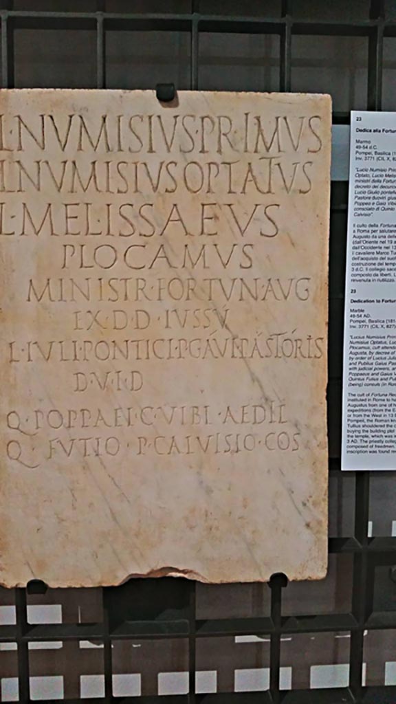 VIII.1.1 Pompeii. June 2017. Found 1814.
Marble Dedicatory inscription (from 49-54AD) to Lucius Numisius Primus, Lucius Numisius Optatus, Lucius Melissaeus Plocamus, ministry of Fortuna Augusta.
Photo courtesy of Giuseppe Ciaramella. 
Now in Naples Archaeological Museum, inv. 3771. (CIL X 827 = ILS 6384).
According to the information card in the Museum –
“The cult of Fortuna Redux was instituted in Rome to hail the return of Augustus from one of his military expeditions (from the east in 19BC or from the west in 13 BC).
At Pompeii, the Roman knight Marcus Tullius shouldered the costs for buying the building plot and erecting the temple, which was inaugurated in 3AD.
The priestly collegium is composed of freedmen.
The inscription was found reused”.