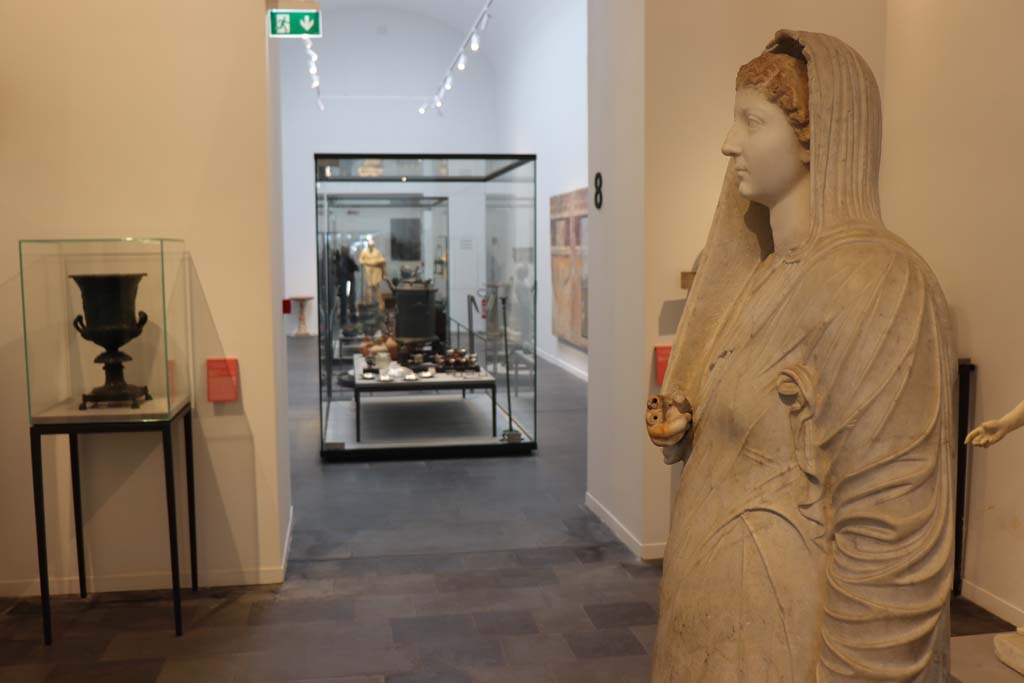 VIII.1.4 Pompeii. February 2021. Looking across Antiquarium, from statue of Livia. Photo courtesy of Fabien Bièvre-Perrin (CC BY-NC-SA).
On the left is the bronze krater found in the triclinium at IX.13.1-3.