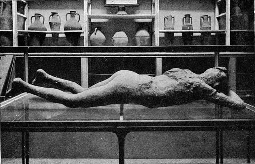 VIII.1.4 Pompeii Antiquarium. About 1892. Cast of woman (Victim number 10) found on Via Stabiana. 
See Dwyer, E., 2010. Pompeii’s Living Statues. Ann Arbor: University of Michigan Press.
Behind are shelves with clay amphorae and jars. Photo courtesy of Rick Bauer.