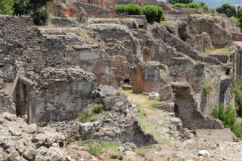 VIII.2.1/3 Pompeii. June 2010. 
Looking across east from area of large room with vaulted ceiling on lower left.
At the rear of this room, centre of photo is the large triclinium “J”, with masonry remains belonging to the walls of rooms/terrace on its south side.
In the centre top of the photo, behind triclinium “J”, the remains of the vaulted ceiling of the large triclinium in VIII.2.3/VIII.2.16 can be seen.
In the upper right of the photo are the rooms belonging to the lower rear rooms of VIII.2.14-16.
Photo courtesy of Sandra Zanella.