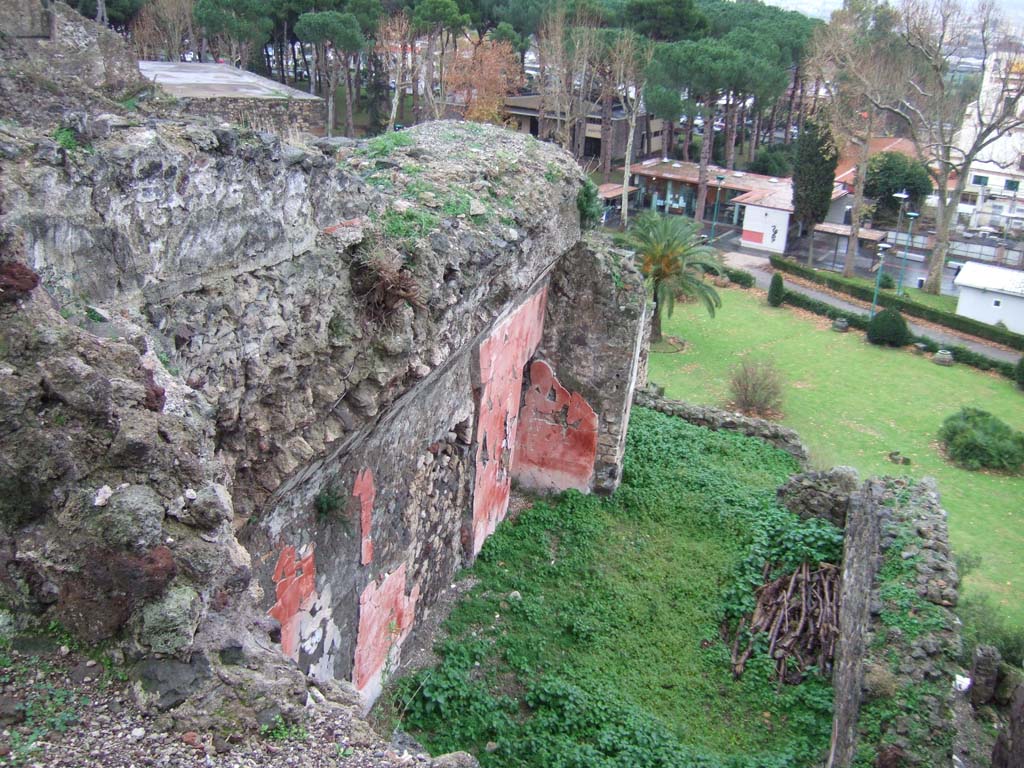 VIII.2.3 and VIII.2.16 Pompeii. December 2005. 
On the left, site of two lower rooms beneath oecus of VIII.2.3.
In the centre a vaulted triclinium belonging to VIII.2.16 (?), lower level, with remains of painted decoration, below room of VIII.2.3 on south-west side.
According to PPM –
“East wall. At the extreme right of the wall was a doorway which had been closed before the making of the plaster painted in the III style.
The zoccolo was white. In the red middle zone, an elegant aedicula was outlined that also continued into the frieze, below this was a painting. 
(PPM thought it was a painting in which a scene set in a landscape could be recognised.)
The epistyle had a frieze with lotus buds, badly taken up in the restoration that could not repeat its peculiarities, and an acroterial swan.
The side panels were red.
The red middle zone of the wall was separated by a white band from the upper zone of the same colour, in which were found, light white architectures with palmettes and acroterial swirls/circles and, in the area above the door a golden medallion (?).  A stucco cornice marks the start of the white vault.”
See Carratelli, G. P., 1990-2003. Pompei: Pitture e Mosaici. VIII. (8). Roma: Istituto della enciclopedia italiana, (p. 93, No.35, 36 and 37, VIII.2.16).