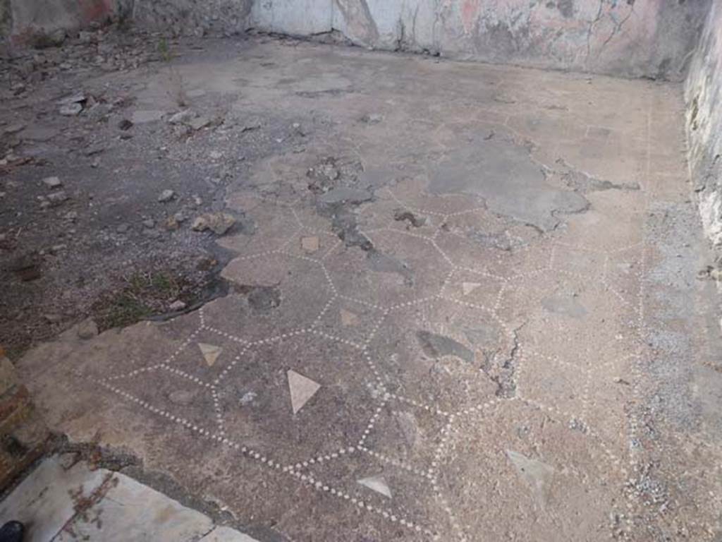 VIII.2.26 Pompeii. September 2011. Room ‘r’, decoration of triclinium floor of cocciopesto, room on west side of vestibule.
There was no design under the couches of the triclinium, in the front of them was placed the “net” of octagons and squares.
In the centre of each was a marble slab/flake and, and in the area of the table, there was a “carpet” of nine circles placed within a frame made by three lines of small tesserae, interspersed with flakes of polychrome marbles and with diamond-shaped tiles at the corners.
Large flakes/scales or tiles of polychrome marble were also in the centre of the circles. 
See Carratelli, G. P., 1990-2003. Pompei: Pitture e Mosaici: Vol. VIII. Roma: Istituto della enciclopedia italiana, p. 206.
In the left lower corner, the marble doorway threshold can be seen.
When excavated the walls would have been painted in the IV style, with a red zoccolo containing panels showing a ‘carpet’ border.
The middle zone of the walls would also have been painted red, with panels separated by architectural motifs.
The west wall was seen to have black side panels, on either side of a red central panel.