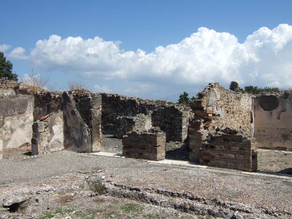 VIII.2.26 Pompeii. September 2005. North-east corner of the atrium. Doorway to room ‘e’ on the left, two doorways leading into room ‘h’ the kitchen area, (in centre), and doorway to room “L” on the right.