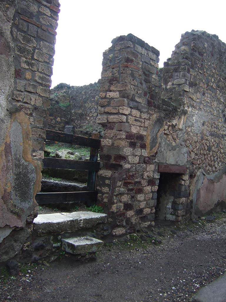 VIII.2.27 Pompeii. December 2005. 
Looking through doorway with steps to kitchen area of VIII.2.26, and window of underground room, on right.