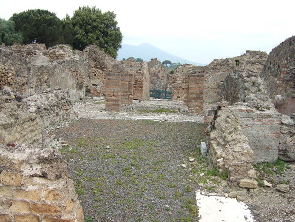 VIII.2.29 Pompeii. September 2005.  Looking north across tablinum to atrium and entrance doorway. In the north-west corner of the atrium would have been a masonry lararium, (in the area to the left of the brick pilasters). According to Boyce, this lararium was later in date than the stucco of the walls of the room. The walls were in the IVth Style.
Around the base of the lararium ran a dado of marble. In this corner of the atrium the black border in the mosaic pavement was made to run around the two sides of the podium. This marked its position.
According to Mau, some other object stood here before the construction of the lararium. These would have been either the arca for the money, or a smaller and more modest lararium, which was then enlarged.
Not. Scavi, 1883, 135. Bull. Inst, 1885, pp.88, 93.
See Boyce G. K., 1937. Corpus of the Lararia of Pompeii. Rome: MAAR 14. (p.74, no. 346) 
According to Giacobello, only the podium survives of the aedicula in the north-west corner of the atrium.
See Giacobello, F., 2008. Larari Pompeiani: Iconografia e culto dei Lari in ambito domestico.  Milano: LED Edizioni. (p.247)