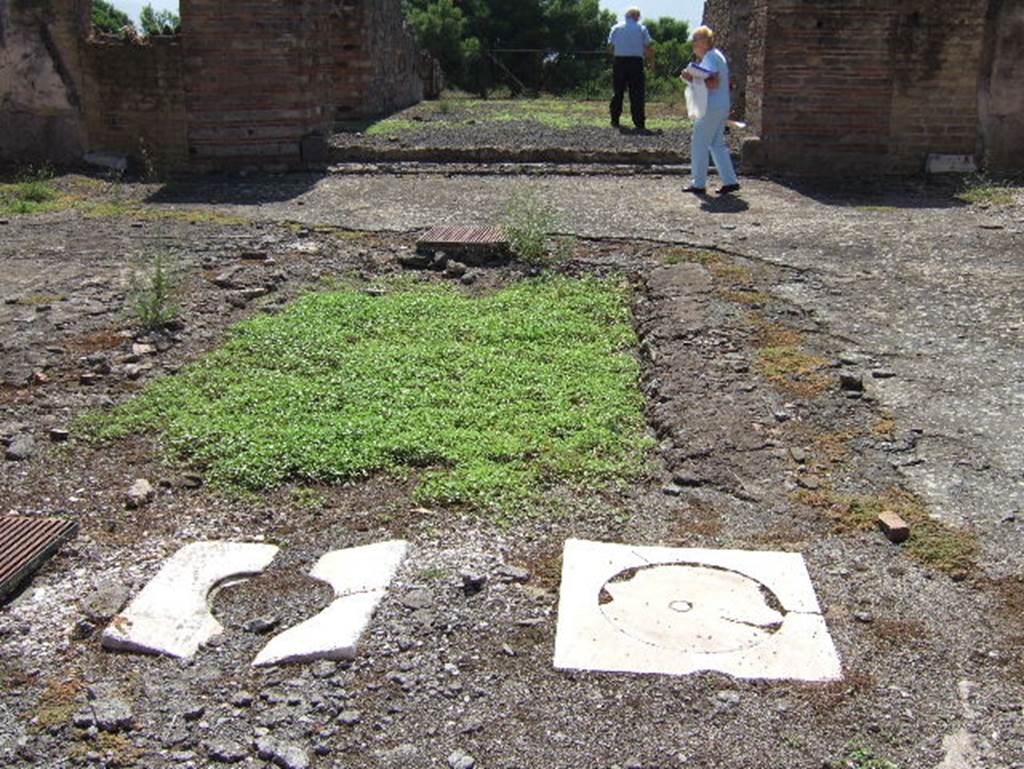 VIII.2.30 Pompeii. September 2005. Impluvium in atrium, with four cistern-mouths. Originally all four would have been of travertine. The one on the left, replaced with a brown metal grid now, was originally incised with the letter “D” on the left, and on its right, the letter “V”. See Bullettino dell’Instituto di Corrispondenza Archeologica (DAIR), 1885, p.93.