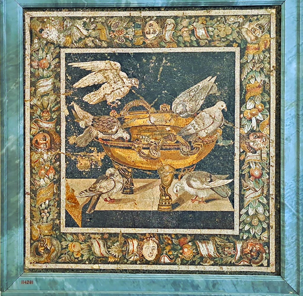 VIII.2.34 Pompeii. Emblema from floor, found in March 1885 in room ‘n’. 
Now in Naples Archaeological Museum.  Inventory number 114281. Photo courtesy of Giuseppe Ciaramella. September 2024.
According to the information card –
Doves drinking from a basin.
Mosaic emblema in opus vermiculatum made from polychrome tesserae.
The mosaic, inspired by a prototype by Sosus of Pergamon, depicts doves drinking from a bronze basin. 
The scene is framed by a garland of fruit, ribbons, masks and berries. (First quarter of the Ist century BC.)
(Colombe che si abbeverano.
Emblema pavimentale in opus vermiculatum di tessere policrome.
Il mosaico, ispirato al prototipo di Sosos di Pergamo, raffigura delle colombe che bevono attorno a un bacino bronzeo. La scena è inquadrata da una ghirlanda di frutta, nastri, maschere e bacche.  Primo quarto del I secolo a.C.)