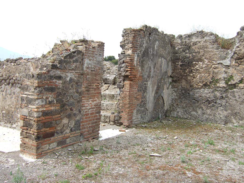 VIII.2.34 Pompeii. May 2006. Looking south-west from atrium. On the left is the doorway to room ‘m’.
In the centre of the south wall of room ‘i’, the west ala, is the doorway to room ‘o’ with stairs to upper floor, and latrine beneath.
