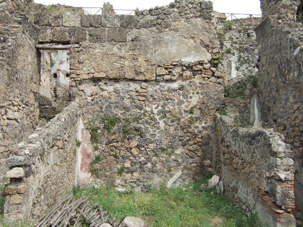 VIII.2.34 Pompeii. May 2006. Room ‘8’, looking north across middle triclinium on lower level.
The walls of this large room, which made up the central residential space of this lower floor, showed a painted black zoccolo, purple panels with blue borders. Mau defined the decoration as of a candelabra on a peacock-blue/purple background. The room was covered with a vaulted ceiling and also two narrow areas to the side, the passageway ‘7’ (on the left) and the narrow area (on the right) perhaps a store-cupboard. In the rear wall of the store-cupboard was a window opening into the corridor ‘5’. The cocciopesto floor had polychrome ‘crustae’, and a threshold of well-executed white meander tesserae, which separated this from its anteroom.
