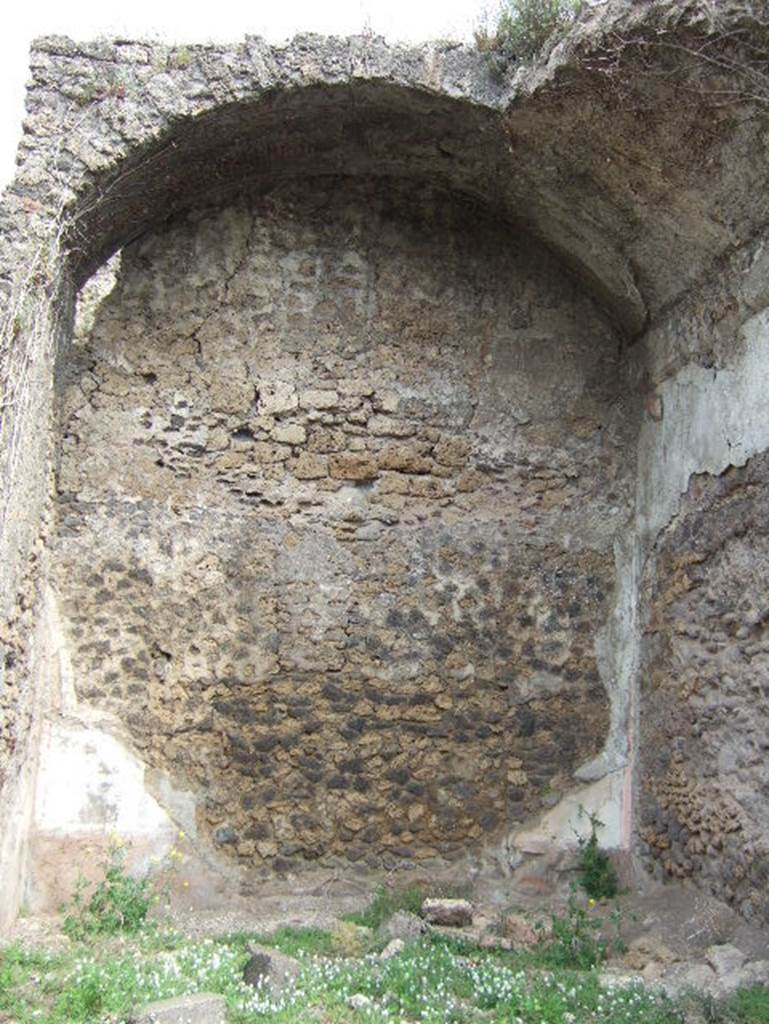 VIII.2.34 Pompeii. May 2006. Room ‘10’, north wall of triclinium on east side of lower level.
Originally the flooring would have been a black mosaic with rows of crosses of small tesserae with a white border, similar to the atrium ‘c’.  Nothing of this can be seen now, and the only remains of painted wall plaster can be seen on the north wall, protected by the vaulted ceiling. The zoccolo was black, and like the middle zone was crossed in panels with candelabra; red on the upper part, a red band protruding crowned at the top with a stucco cornice.