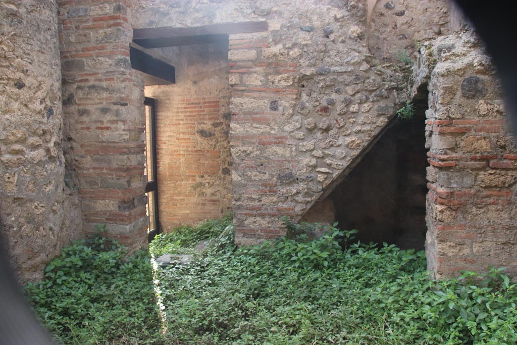 VIII.2.38 Pompeii. October 2023. 
Looking south to doorway to kitchen and steps to upper floor, with recess below. Photo courtesy of Klaus Heese.