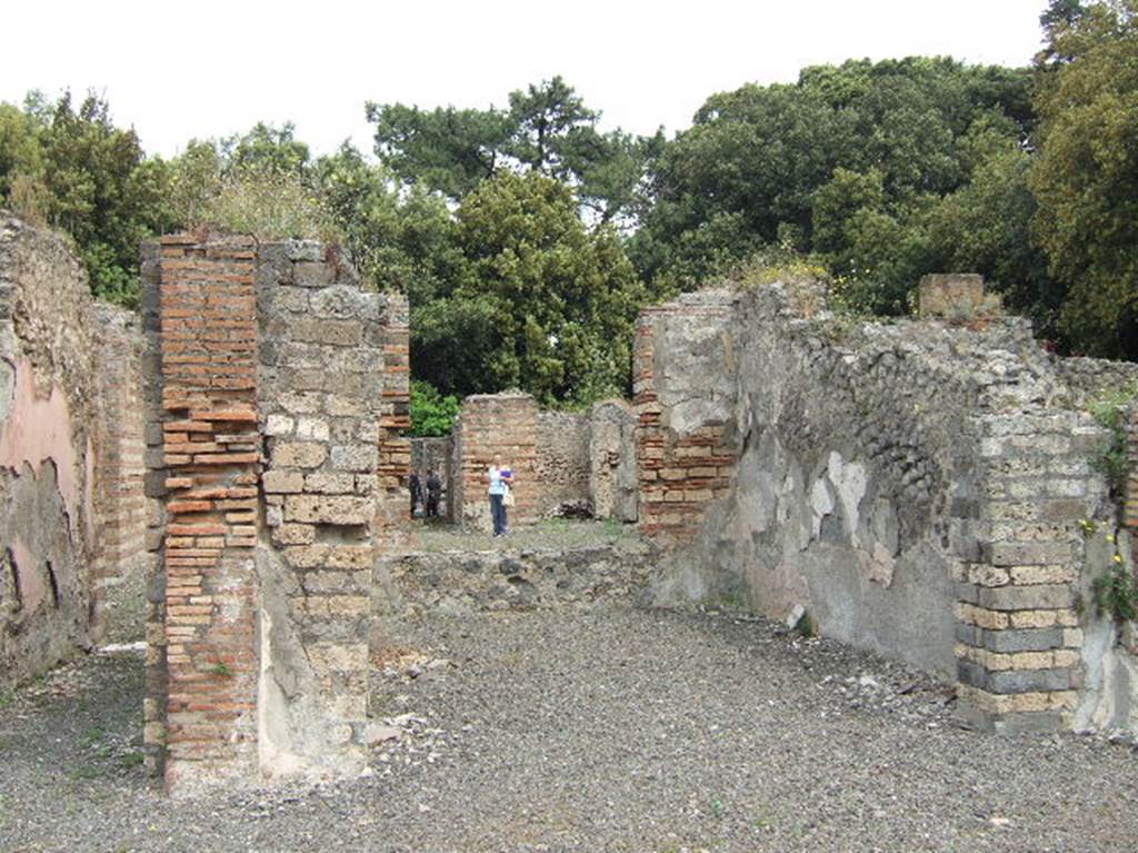 VIII.2.39 Pompeii. May 2006. Room r, tablinum, from large room, w.  
Looking north across tablinum, towards atrium and entrance doorway.
According to Jashemski, all of the rooms at the rear of this house were built out over the south wall of the city. At the rear on the street level, the large room w, and the triclinia on either side of it (rooms v and x) were completely open onto the portico that preceded the terrace.
See Jashemski, W. F., 1993. The Gardens of Pompeii, Volume II: Appendices. New York: Caratzas. (p.209 and fig 244, reconstruction of rear of house).