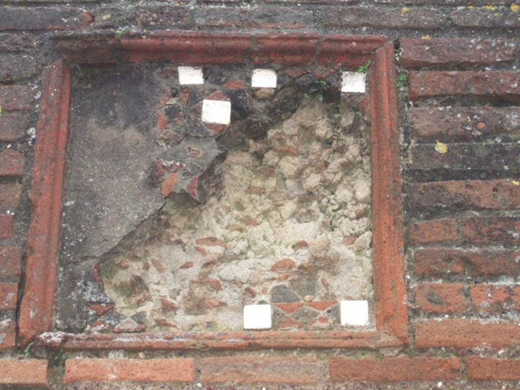 VIII.3.5 Pompeii. December 2005.  Remains of plaque with pieces of tessellated stone and mosaic on wall between VIII.3.6 and VIII.3.5.