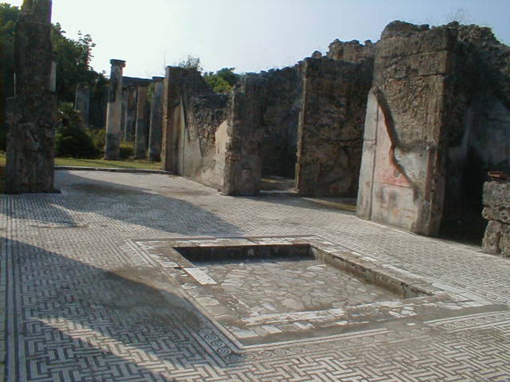 VIII.3.8 Pompeii. September 2004. 
Looking south-west across atrium and decorated impluvium, towards tablinum, doorway to oecus and west ala, open onto atrium.