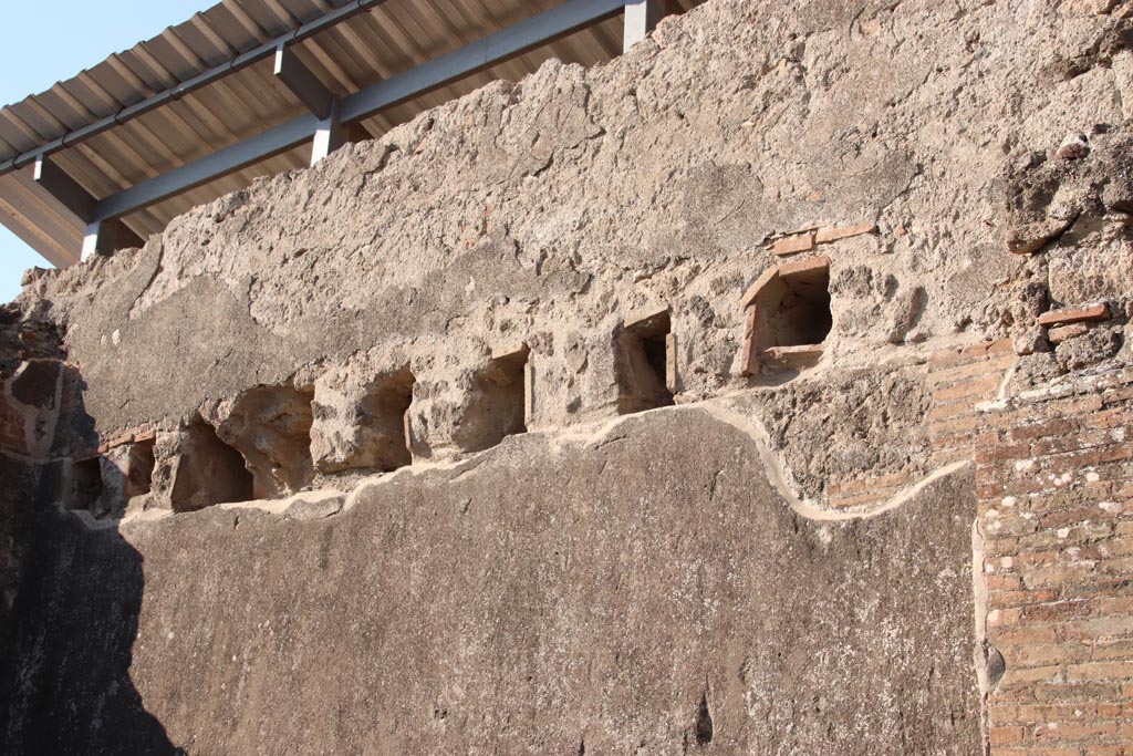 VIII.3.9 Pompeii. October 2022. Upper west wall, detail of holes for beams to support the upper floor. Photo courtesy of Klaus Heese.