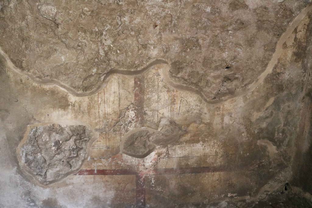 VIII.3.11, Pompeii. December 2018.  
Looking towards painted decoration at base of vaulted west wall of cubiculum. Photo courtesy of Aude Durand.
According to PPM – the west wall was decorated with zoccolo and middle zone of wall in white by red lines and bands. 
See Carratelli, G. P., 1990-2003. Pompei: Pitture e Mosaici. (8). Roma: Istituto della enciclopedia italiana, (p.393, no.14.)